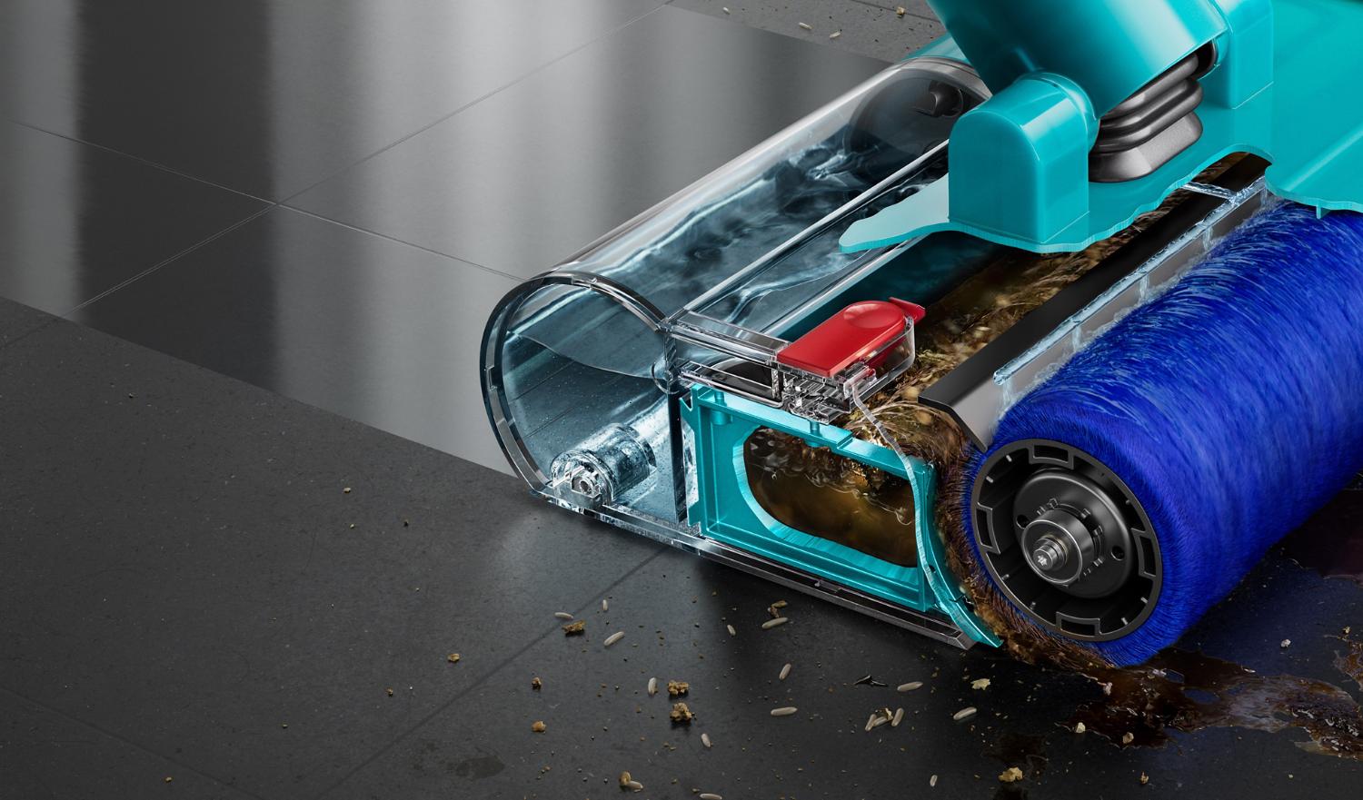 Cutaway closeup of the Motorised wet roller on a stone floor with some debris to the front and side leaving behind a clean sheen.